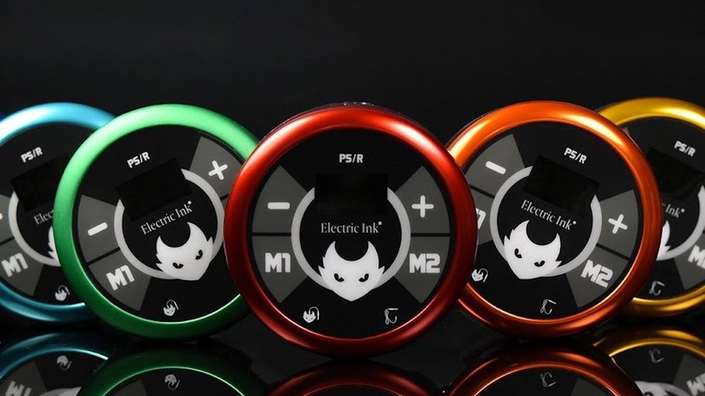 Five round Electric Ink power supplies in a row, anodized teal, green, red, orange and yellow, on black